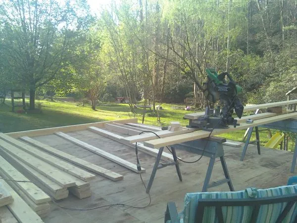 Miter saw and framing lumber on a deck under construction in Portsmouth